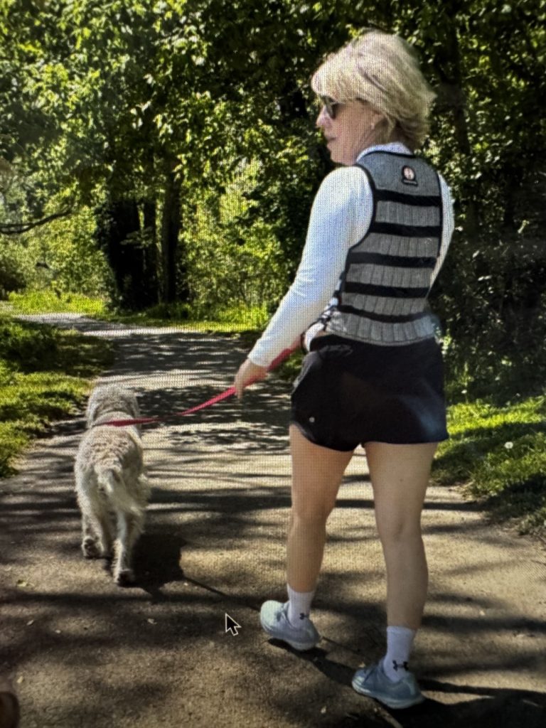 Adrienne Freeland wears a weighted vest while on a walk with her dog. Freeland has incorporated the vest into her fitness routine.